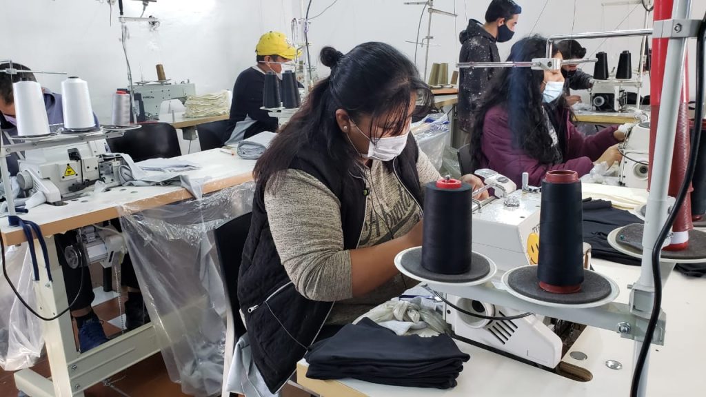 Una mujer trabaja dentro de un taller de una cooperativa